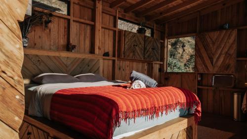 a bedroom with a bed in a wooden cabin at Lake Atitlán Panorama Chalets in San Marcos La Laguna