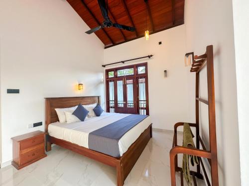 a bedroom with a bed and a window at Villa Yoniky - Weligama in Weligama