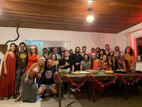a group of people posing for a picture at a table at Nômades Riverside - Adventure Hostels & Coworking in Florianópolis
