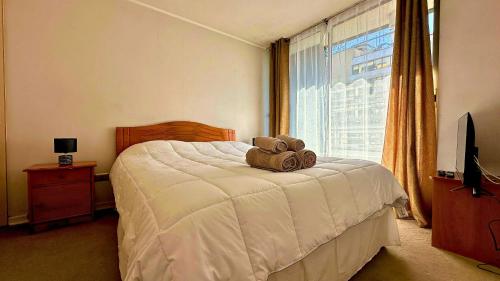 a teddy bear sitting on a bed in a bedroom at Viña Sunset Escape in Viña del Mar