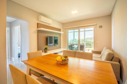 a dining room with a table with a bowl of fruit at Apartamento vista para o mar com 02 dormitórios in Canto Grande