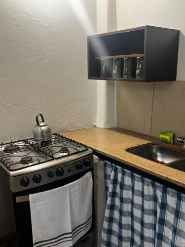 a stove in a kitchen with a tea kettle on it at Monarcas II in Villa Carlos Paz
