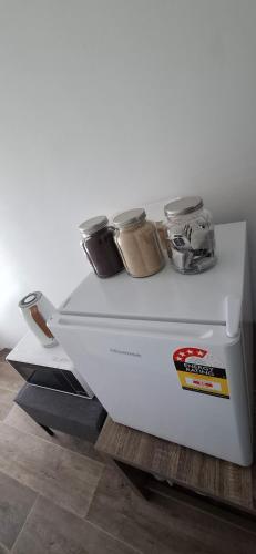 a white refrigerator with jars on top of it at Lake side Master Room in Kelmscott