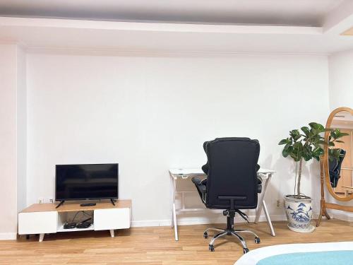 仁川市温馨小屋Cozy House的卧室里有一张桌子、一把椅子和一台电视机