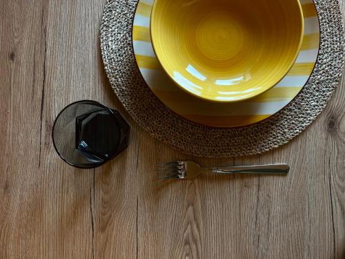 ein gelber Teller und eine Gabel auf einem Tisch in der Unterkunft Dimidia - casa vacanze mare montagna in Capaci