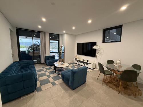 a living room with a blue couch and a table at The Gosford Modern Nest in Gosford