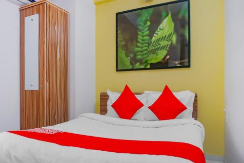 浦那Collection O Baner Hillview Pune Formerly Siri Lodge的卧室里有一张大床，配有红色枕头