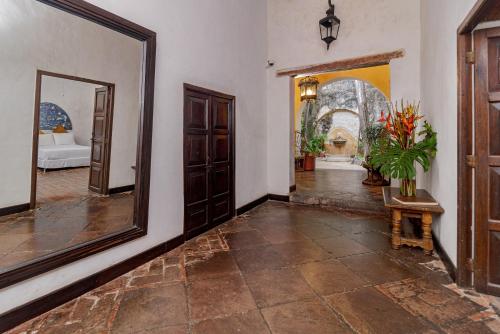 a hallway with a mirror and a room with a bed at Casa Baloco in Cartagena de Indias