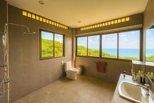 une salle de bain avec un lavabo et des toilettes et des fenêtres dans l'établissement Canopy Panorama Residence Double suite, à Haad Yuan