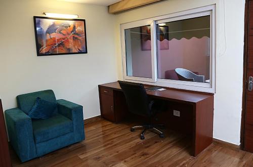 an office with a desk and a chair and a window at Hotel Cama in Chandīgarh