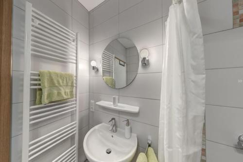 a white bathroom with a sink and a mirror at Großzügige Ferienwohnung für bis zu 9 Personen in Burhave