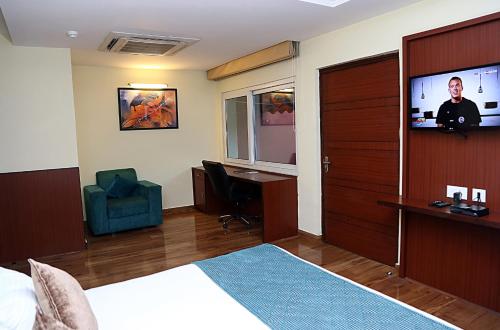 a hotel room with a bed and a flat screen tv at Hotel Cama in Chandīgarh