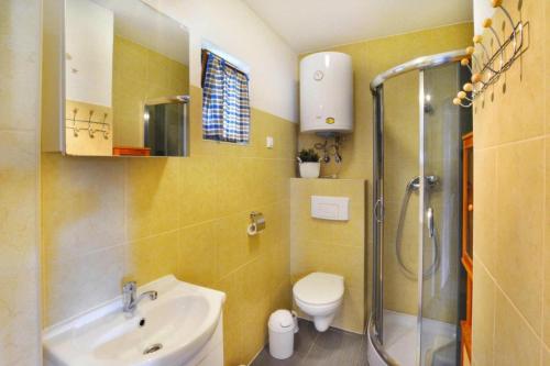 a bathroom with a sink and a toilet and a shower at Comfortable holiday homes close to the beach in Bobolin