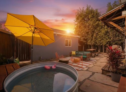 une piscine avec un parasol jaune et une terrasse dans l'établissement Modern Retro Close to DT, Zoo, Parking, Hot Tub, à San Diego