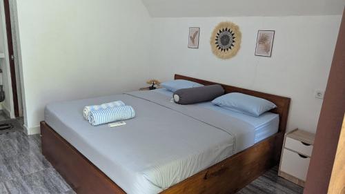a bedroom with a bed with blue pillows on it at Stokel Cottage in Praya