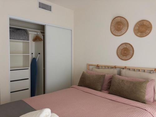 a bedroom with a bed with pink sheets and pillows at Surfside Retreat-Stylish Escape in Bulli