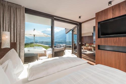 una camera con letto e un balcone con vasca di Hotel Rosengarten (Schenna Resort) a Scena
