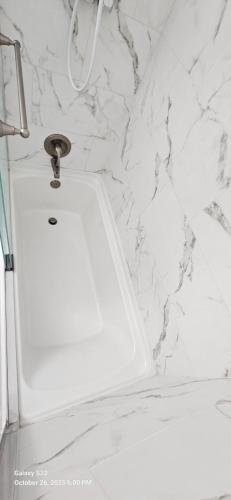 a white sink in a bathroom with a marble wall at Lovely Rural Living in Cherry Valley