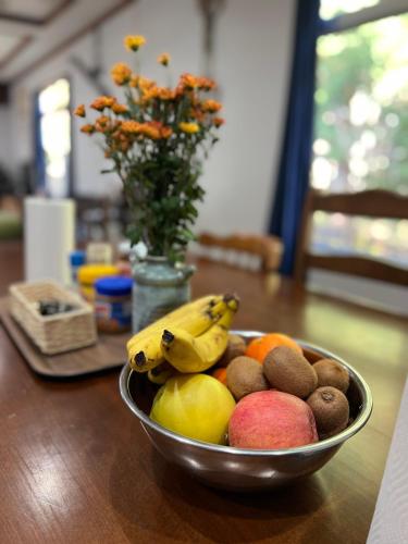 un cesto di frutta su un tavolo con un vaso di fiori di sneaky peaks a Hakuba