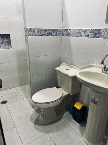 a bathroom with a toilet and a sink at Herrera departamentos in Tepic
