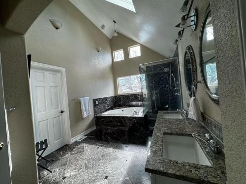 a bathroom with two sinks and a bath tub at Spacious Country Club Golf Course Retreat in Broomfield