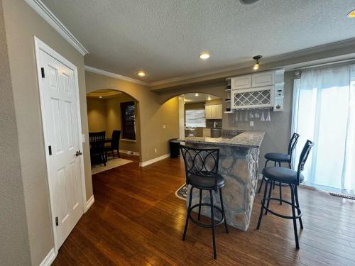 a kitchen and living room with a bar and chairs at Spacious Country Club Golf Course Retreat in Broomfield
