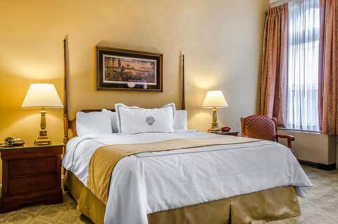 a hotel room with a large bed and two lamps at Heartland suites in Gettysburg