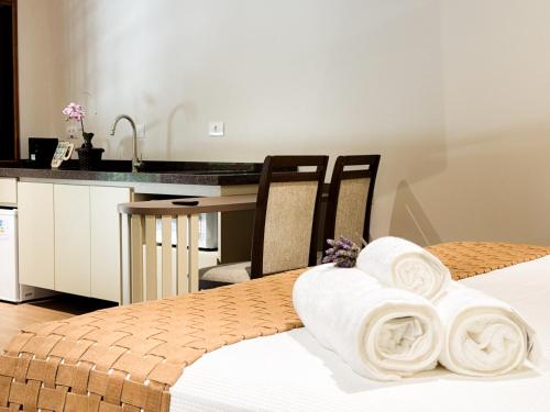a hotel room with two beds with towels at Pousada Flor de Ipe in São Bento do Sapucaí