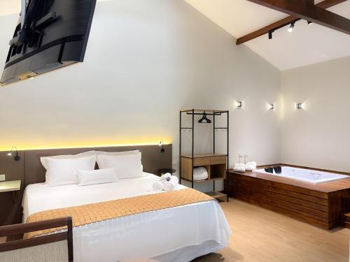 a bedroom with a bed and a bath tub at Pousada Flor de Ipe in São Bento do Sapucaí