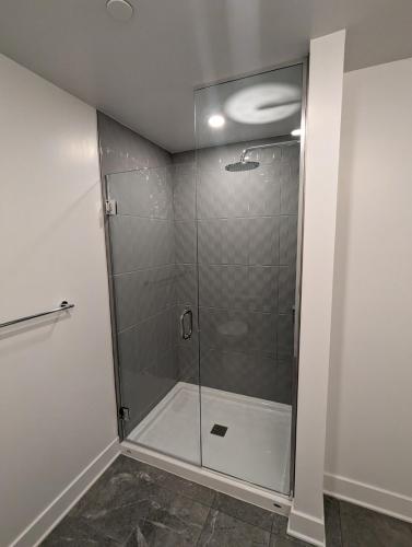 a shower with a glass door in a bathroom at Modern Condo in Ottawa Downtown in Ottawa