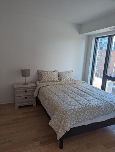 ein weißes Schlafzimmer mit einem Bett und einem Fenster in der Unterkunft Modern Condo in Ottawa Downtown in Ottawa