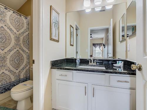 une salle de bain avec un lavabo et des toilettes dans l'établissement Spacious Villa W Pool, Spa & Game Room, à Orlando