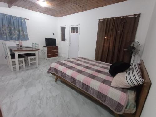 ein Schlafzimmer mit einem Bett, einem Tisch und einem Schreibtisch in der Unterkunft El monito de Sanber in San Bernardo