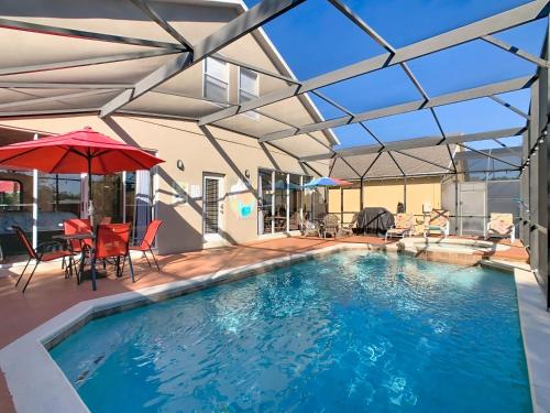 an indoor pool with a glass ceiling and a table and chairs at Family home w pool, spa & game room in Orlando