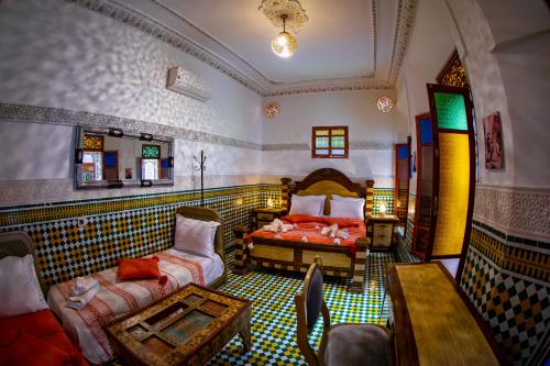 Un dormitorio con una cama y una mesa y sillas. en Riad Layali noor, en Fez