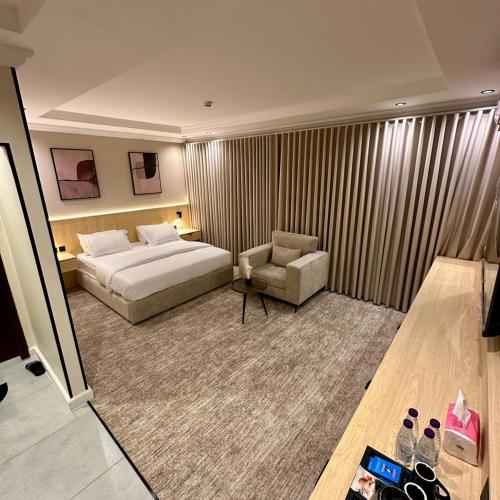a hotel room with a bed and a chair at نسيم الحرم 3 in Ash Shishah
