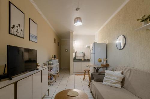 uma sala de estar com um sofá e uma cozinha em Apto 604 vibes em Capão da Canoa