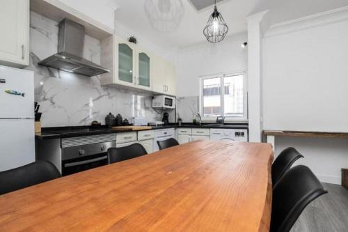 una grande cucina con tavolo e sedie in legno di Cabanas Coastal Escape a Tavira