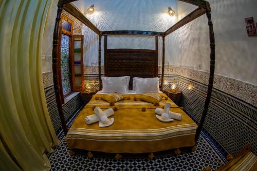 Un dormitorio con una cama con toallas. en Riad Layali noor, en Fez
