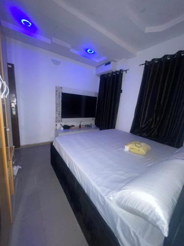 a bedroom with a white bed with a yellow hat on it at Serenity By Mayor in Iranla