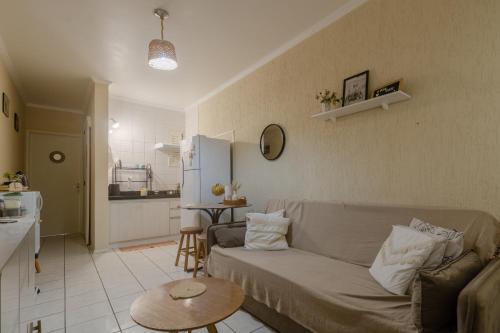uma sala de estar com um sofá e uma cozinha em Apto 604 vibes em Capão da Canoa