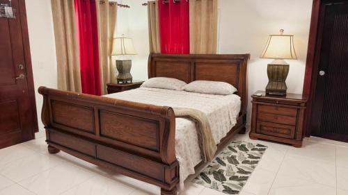 Un dormitorio con una cama de madera y dos mesitas de noche. en Villa luxury Cabarete, en Cabarete