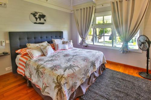 a bedroom with a large bed and a window at Tropical cocoon with 2 bedrooms in Papeete