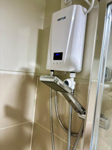 a shower in a bathroom with a water tank at Fame Residence Tower 4 near Greenfield and Shaw MRT in Manila