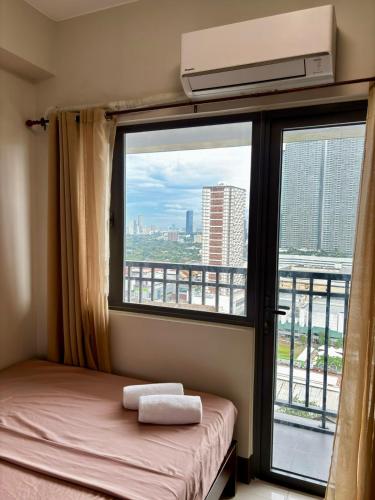 SampongFame Residences 26th Floor Tower 4的一间带床的卧室和一扇可欣赏风景的窗户