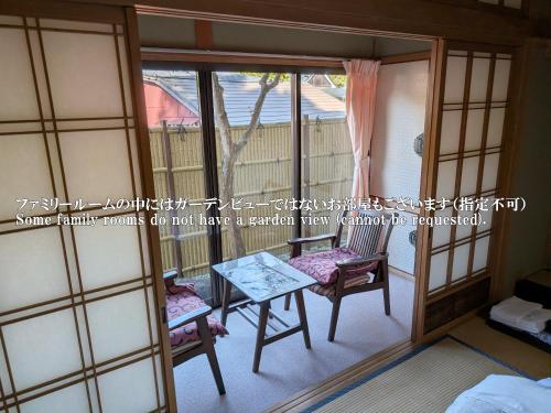 a room with a table and chairs and a balcony at 密厳院 in Koyasan