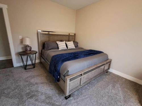 a bedroom with a bed and a side table at Modern 2BR & 2BA New Build Condo w Garage & Patio in Grandville