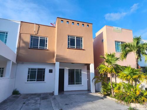 a house with palm trees in front of it at well-deserved rest in Cancun in Cancún