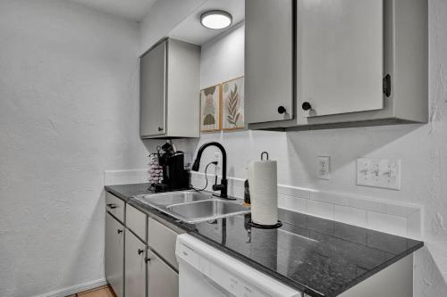 a kitchen with white cabinets and a sink at Near Boone Pickens Stadium - Stillwater Stay in Stillwater