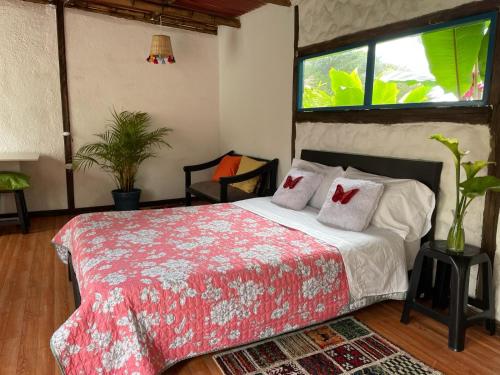 Un dormitorio con una cama con una manta roja y blanca. en Padua Finca Hotel, en Chachagüí